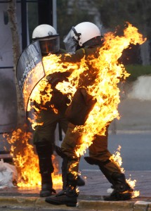 A riot policeman covered in flames runs to escape during in riot in Athens